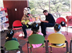 Firefighter and Person in Sparky the Dog Costume Reading to Kids
