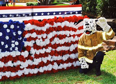 Person in Sparky the Dog Costume in Front of American Flag